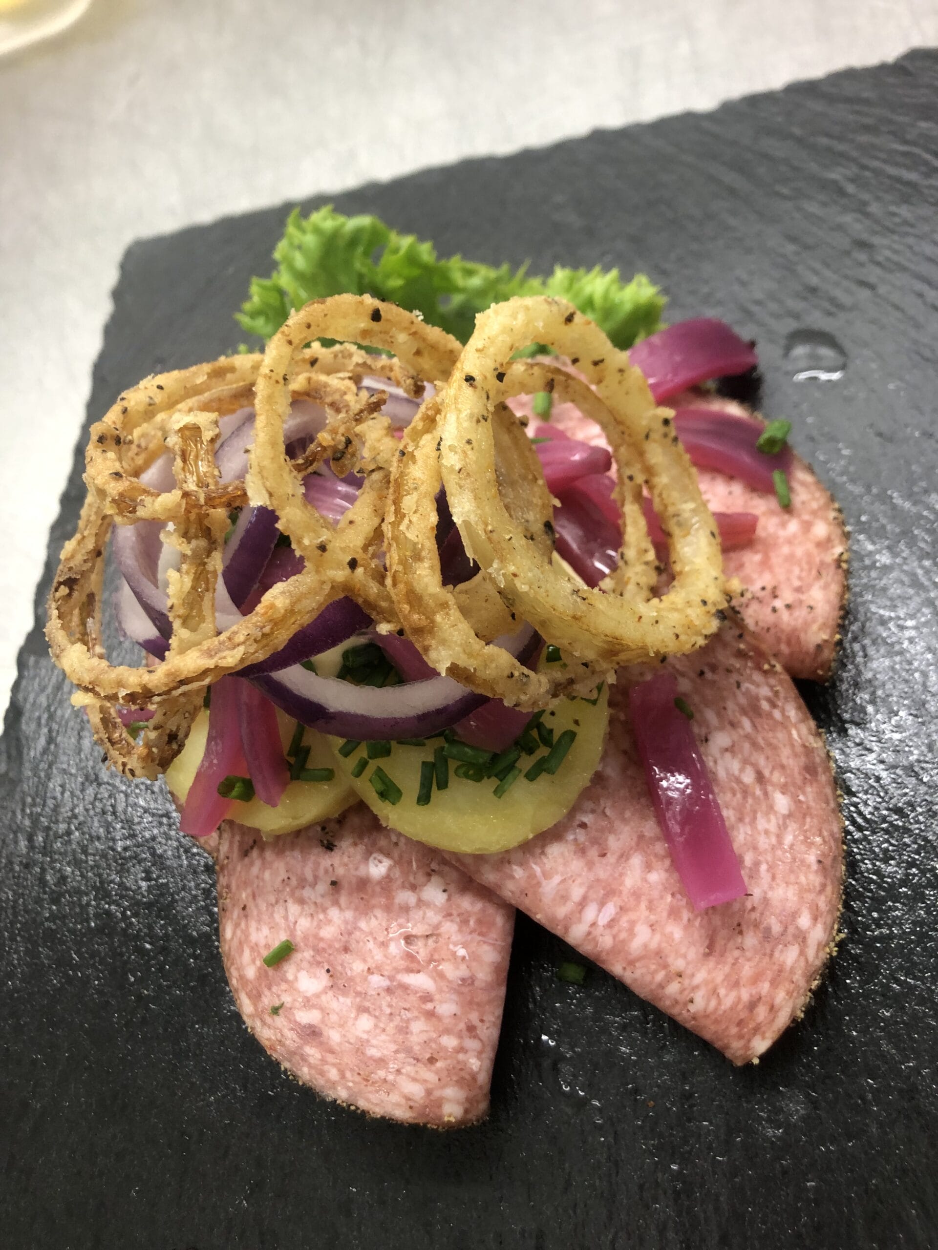 Smørrebrød med spegepølse, kartofler og ristede løg