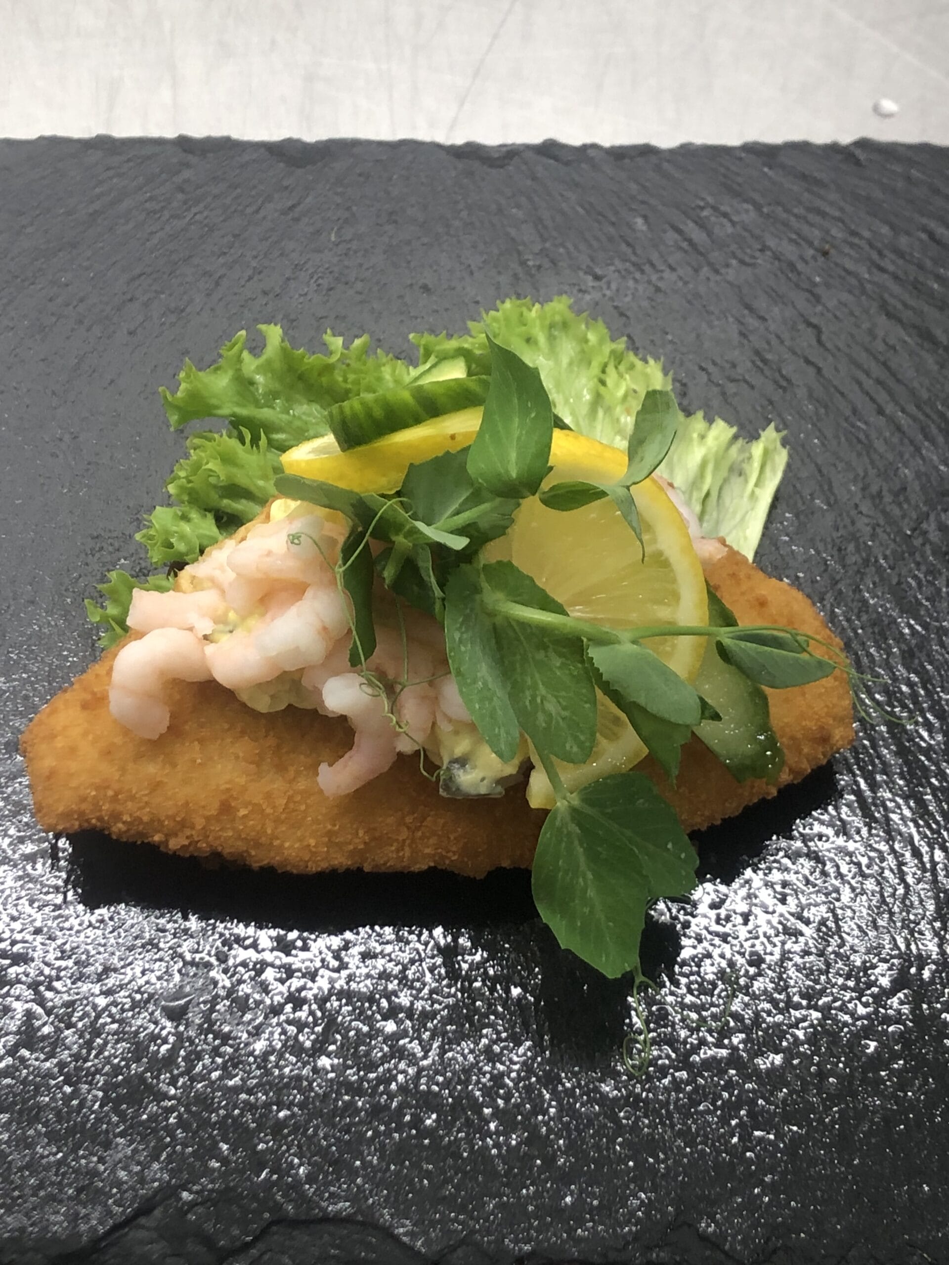 Fiskefilet med rejer, citron og salat på skiferplade